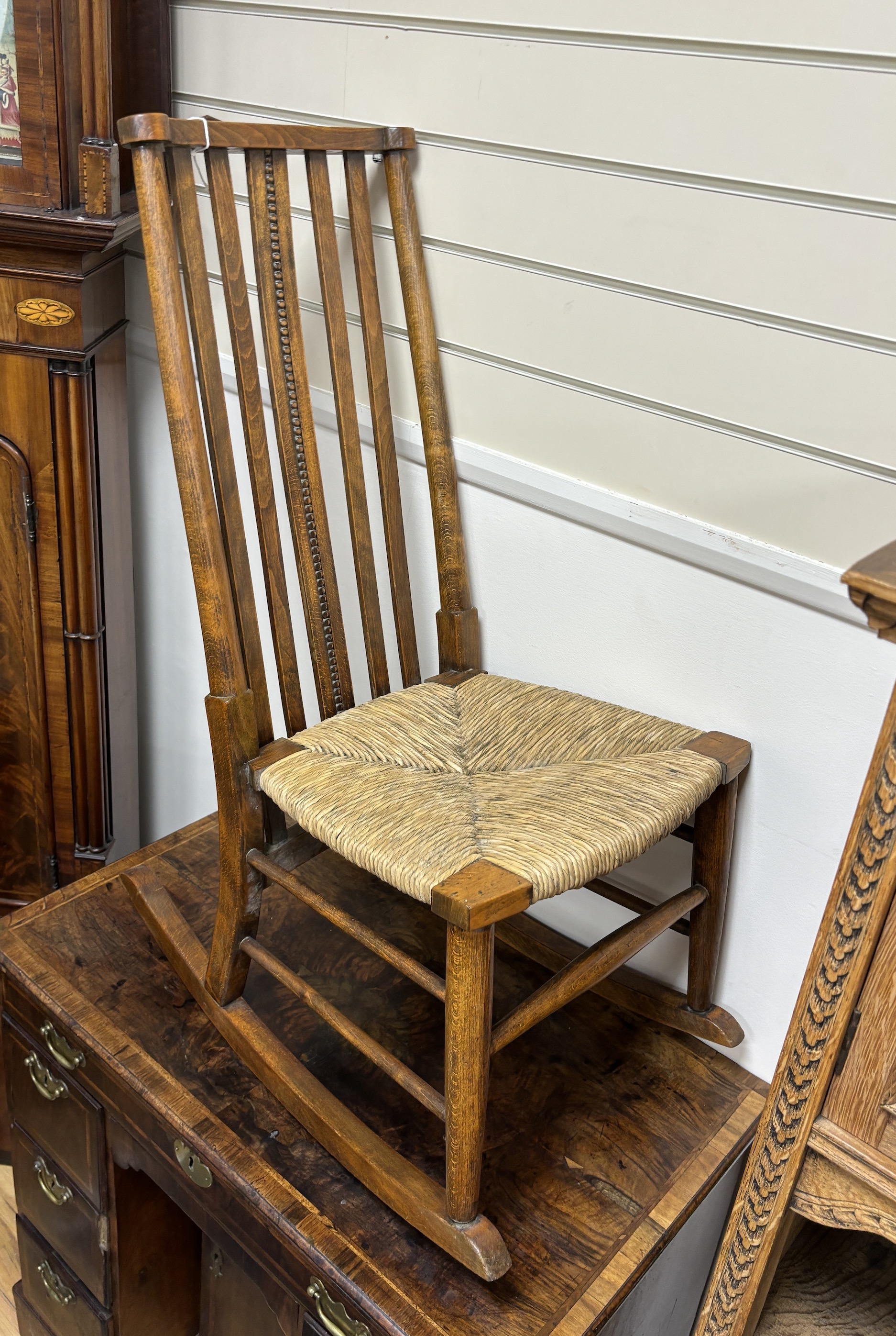 An early 20th century beech rush seat rocking chair, width 40cm, depth 67cm, height 89cm